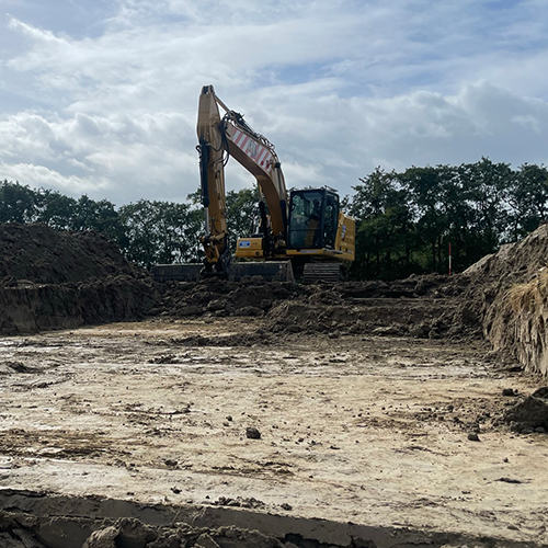 Graafmachine voert grootschalig grondwerk uit op bouwlocatie