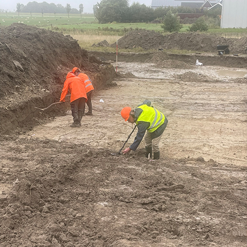 Handmatig grondwerk en uitzetten van bouwterrein door bouwpersoneel